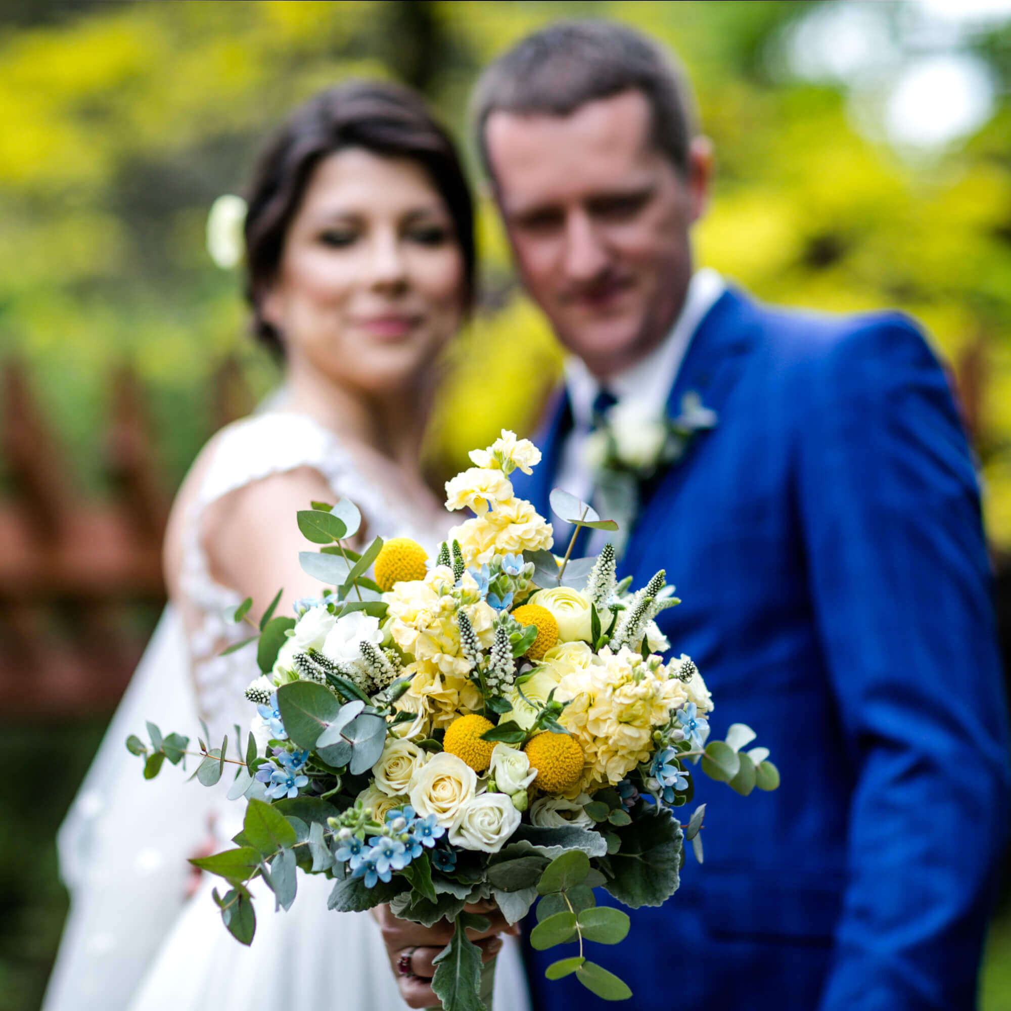 Esküvő fotózás során készült kép Mártiról és Marciról. Márti kezében egy csokor.